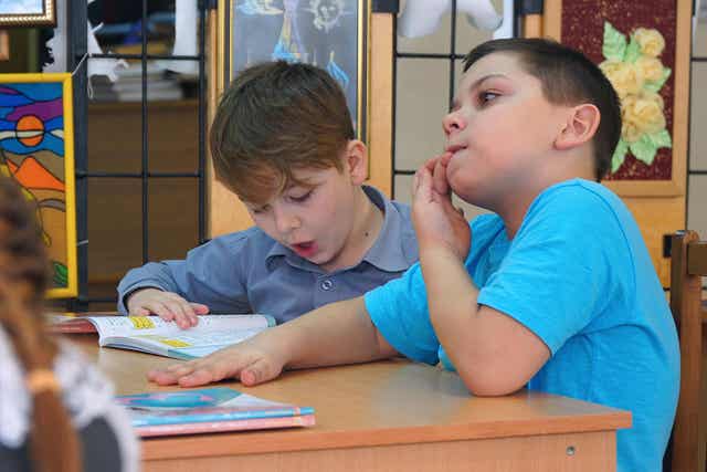 A child biting his nails in class.