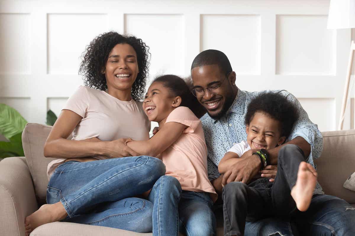 A family laughing together on the couch.