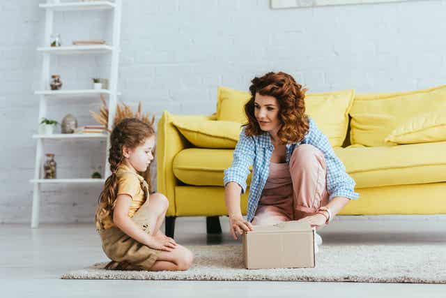 A mom opening a box with her daughter.