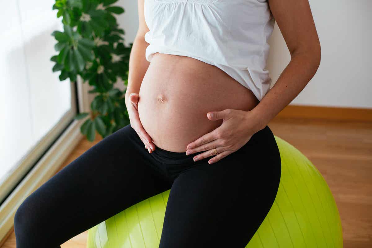 En gravid kvinne på en yogaball.