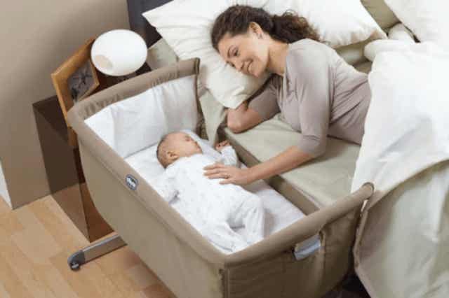 En kvinde sover sammen med sin baby