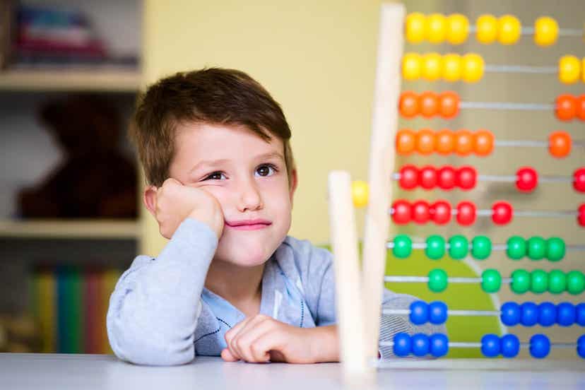 A child sitting by an abacus, looking bored.