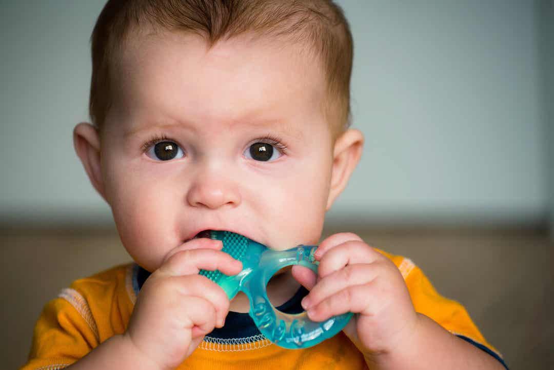 Een baby die op een bijtring kauwt.