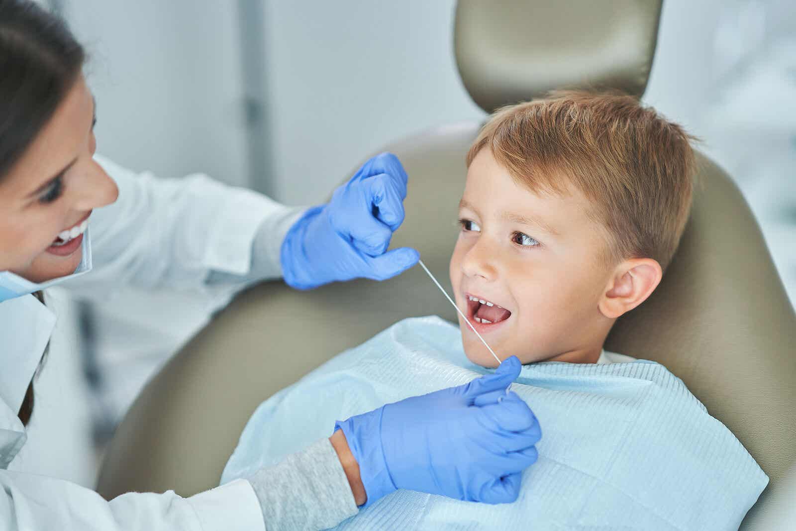 Dreng ved tandlæge med tandtråd for at passe på børns mundhygiejne