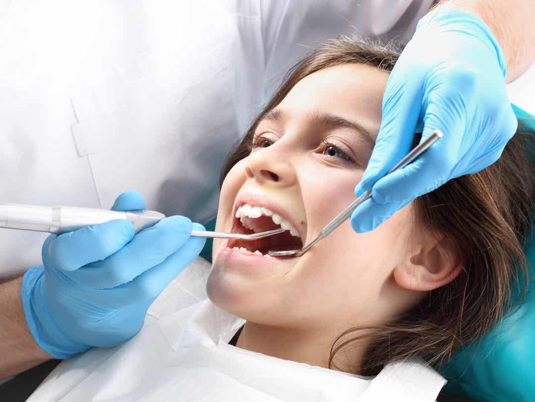 En tandlæge behandler en ung pige