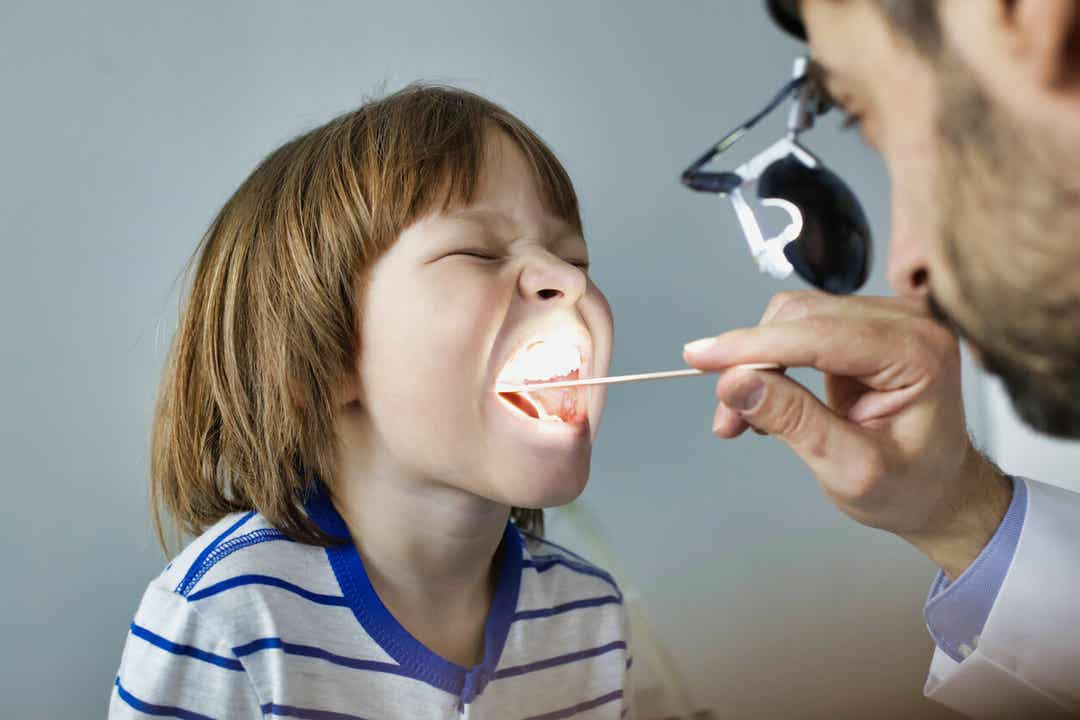A pediatrician checking a child's throat.