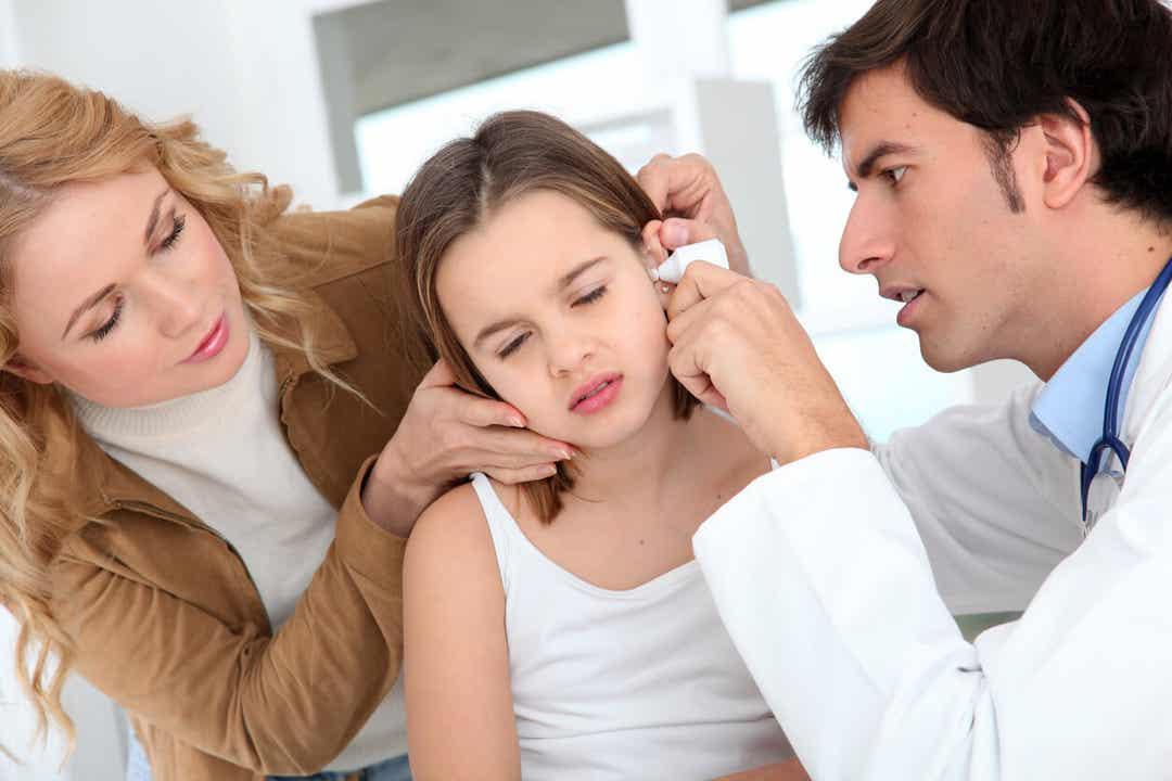 En barnläkare som ser in i ett barns öra.