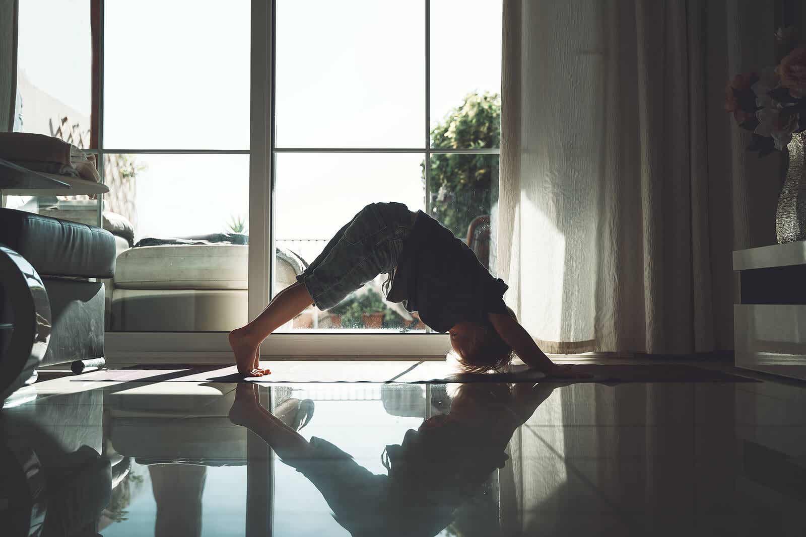A little boy performing yoga exercises.
