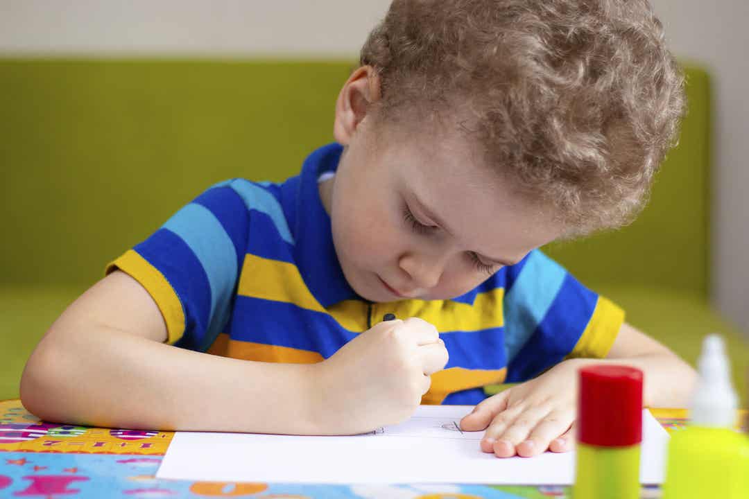 A little boy making a drawing.