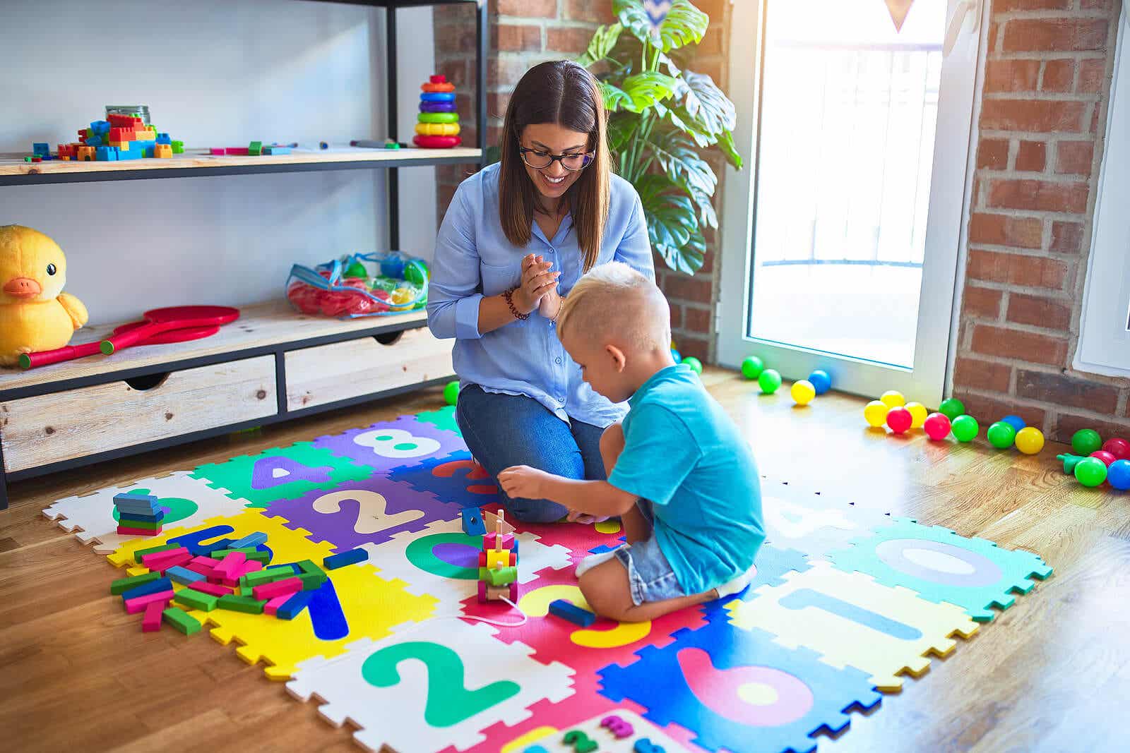 A mother watching her son play on the floor.