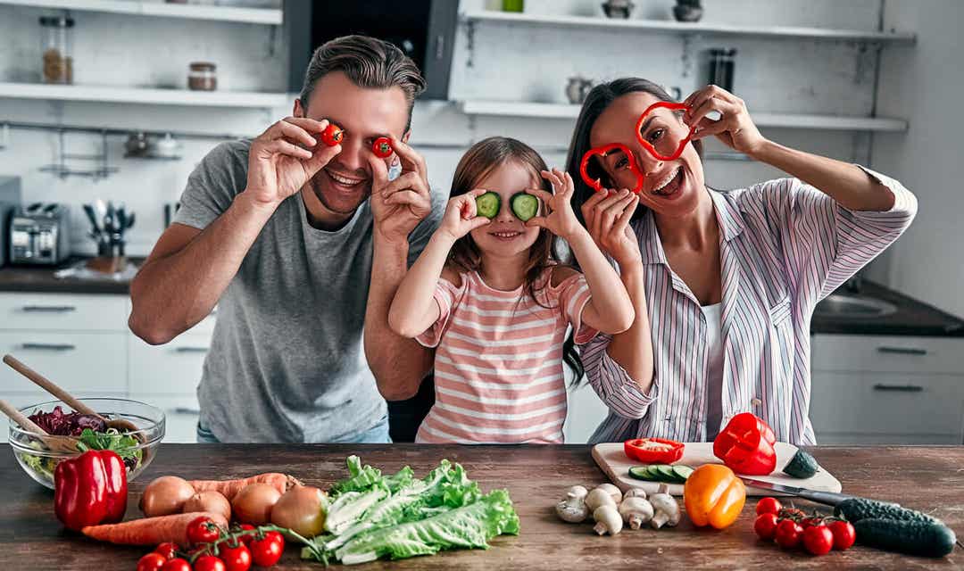 A family playing with vegetables.