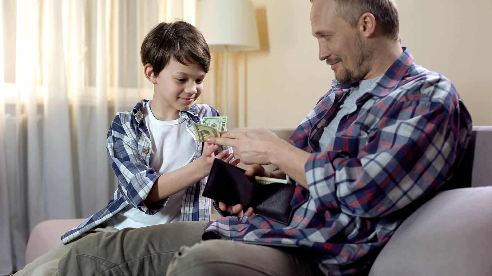 A father giving money from his wallet to his young son.