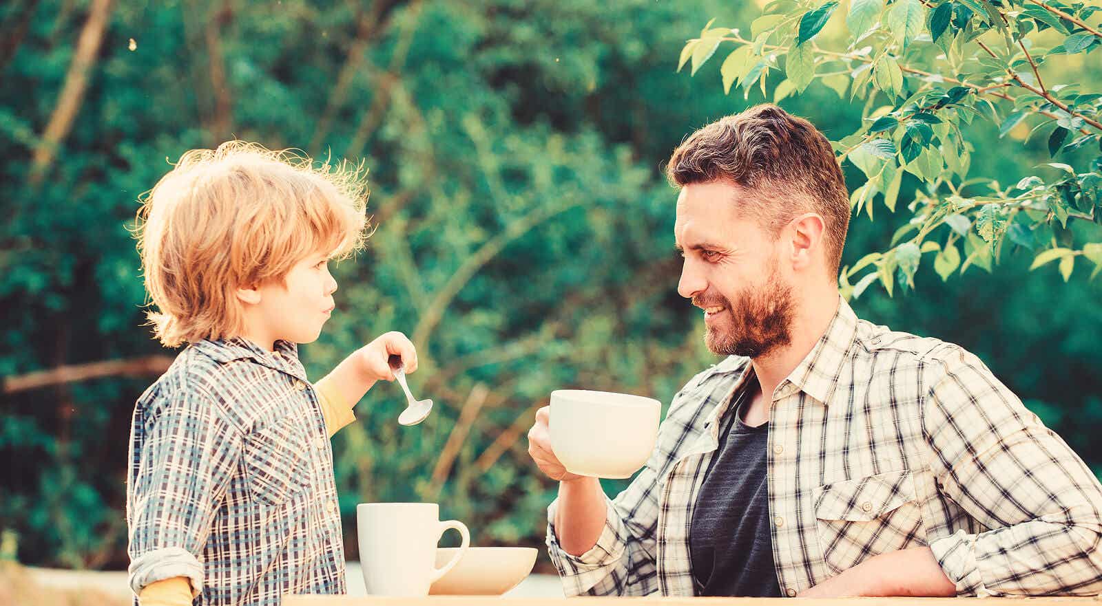 A father drinking having coffee with his son.