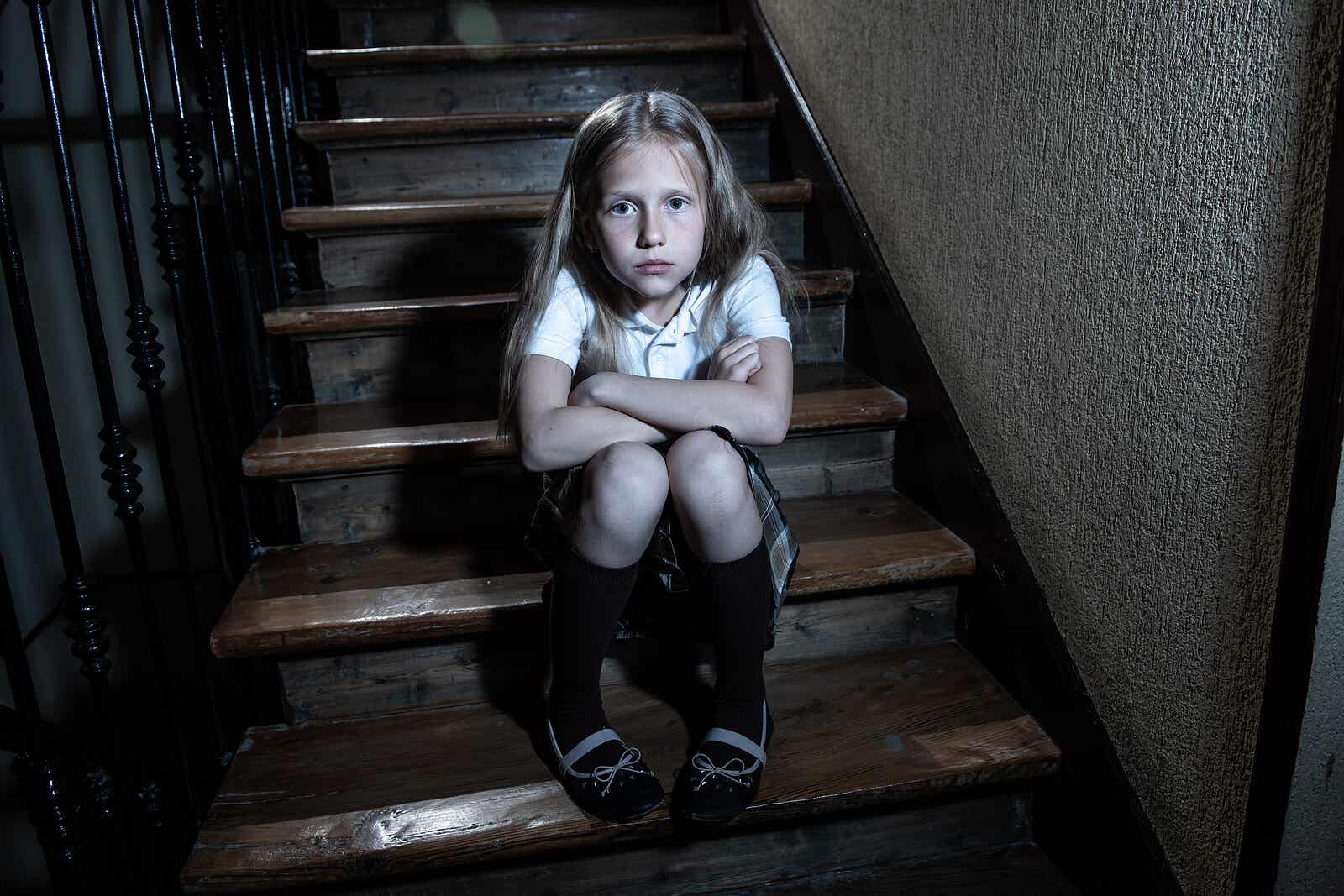 Et barn iført en skoleuniform sidder på trappen i sit hjem