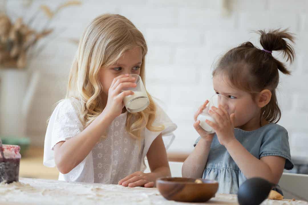Two little girls drinking milk.