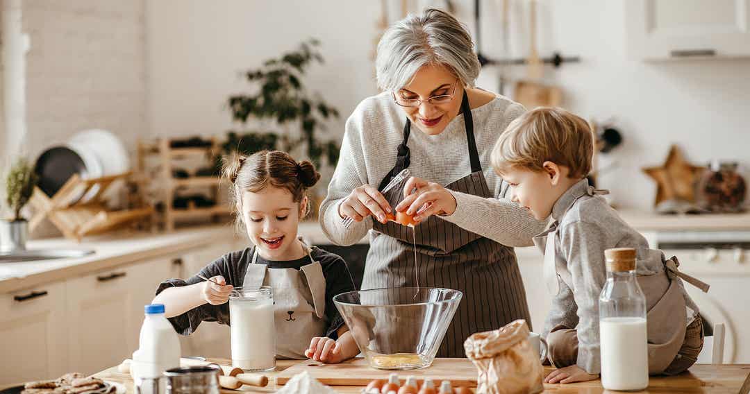 A grandmother baking with her young grandchildren.
