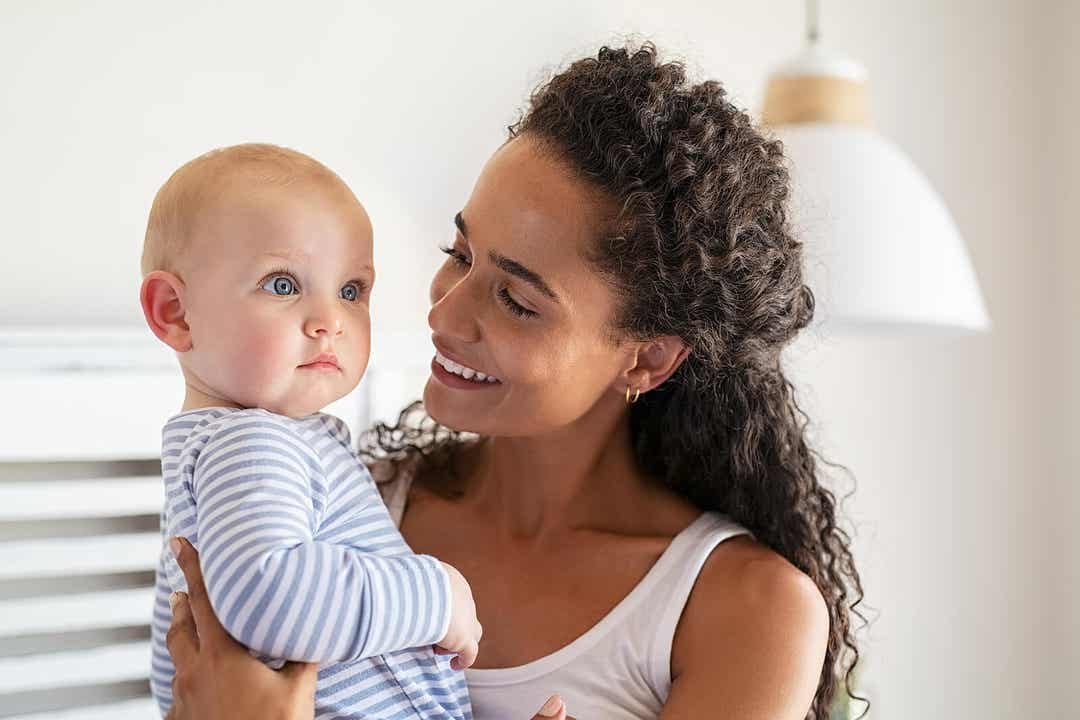 A mother smiling at her baby.
