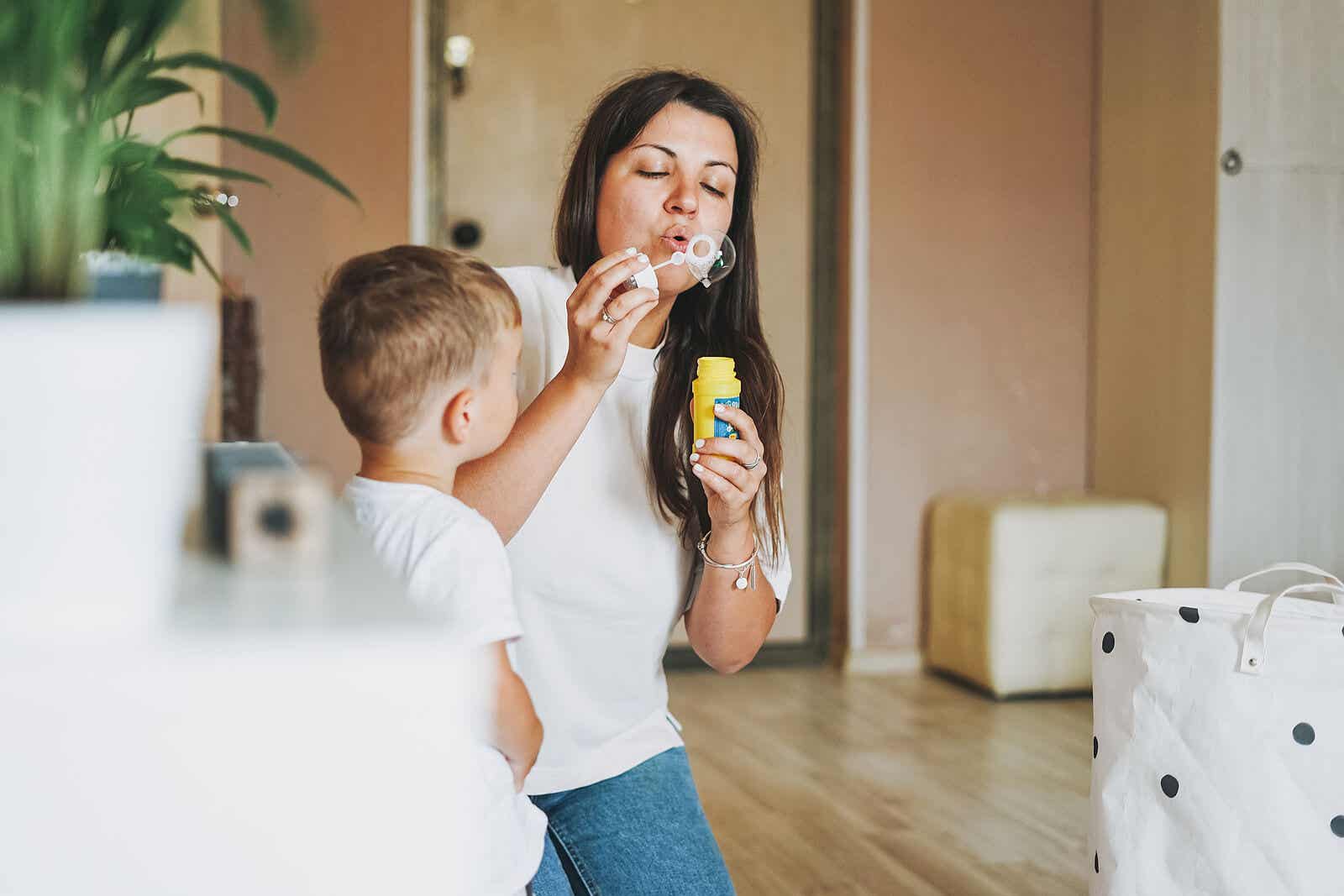 A mother blowing bubbles with her toddler son.