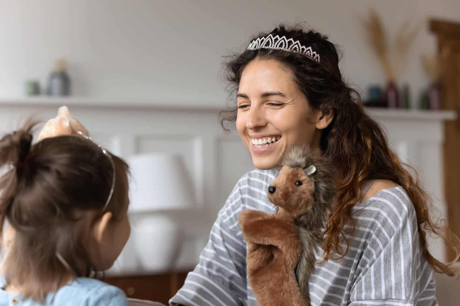 A mother and her daughter playing with puppets.