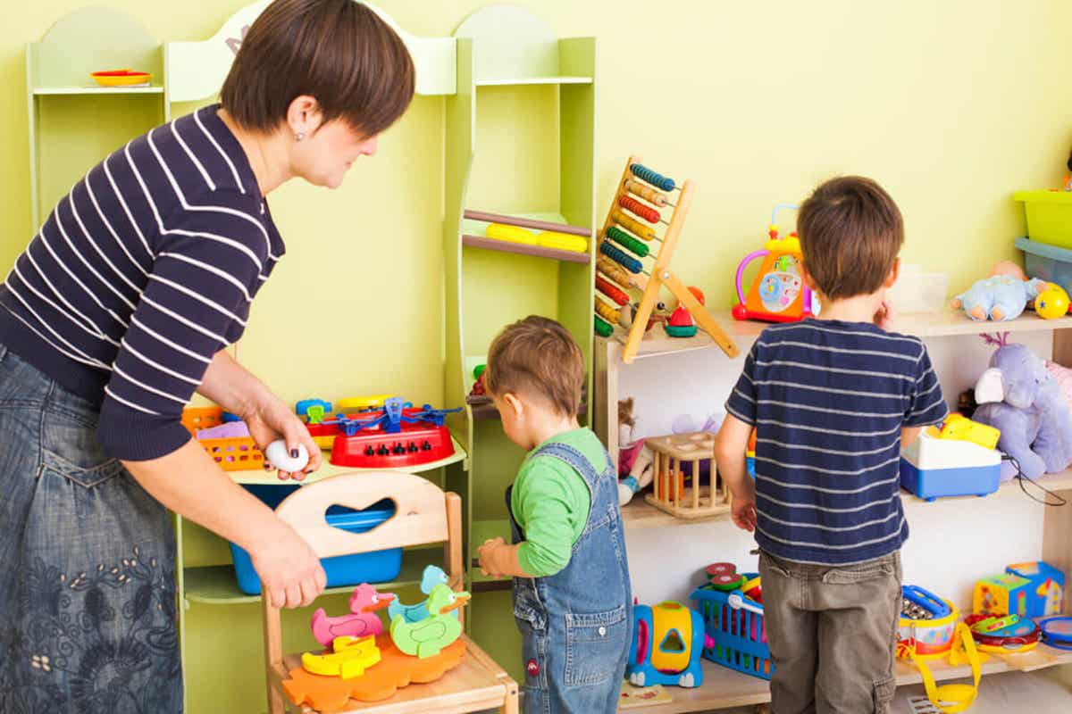 A mother praising her children as they pick up their toys.