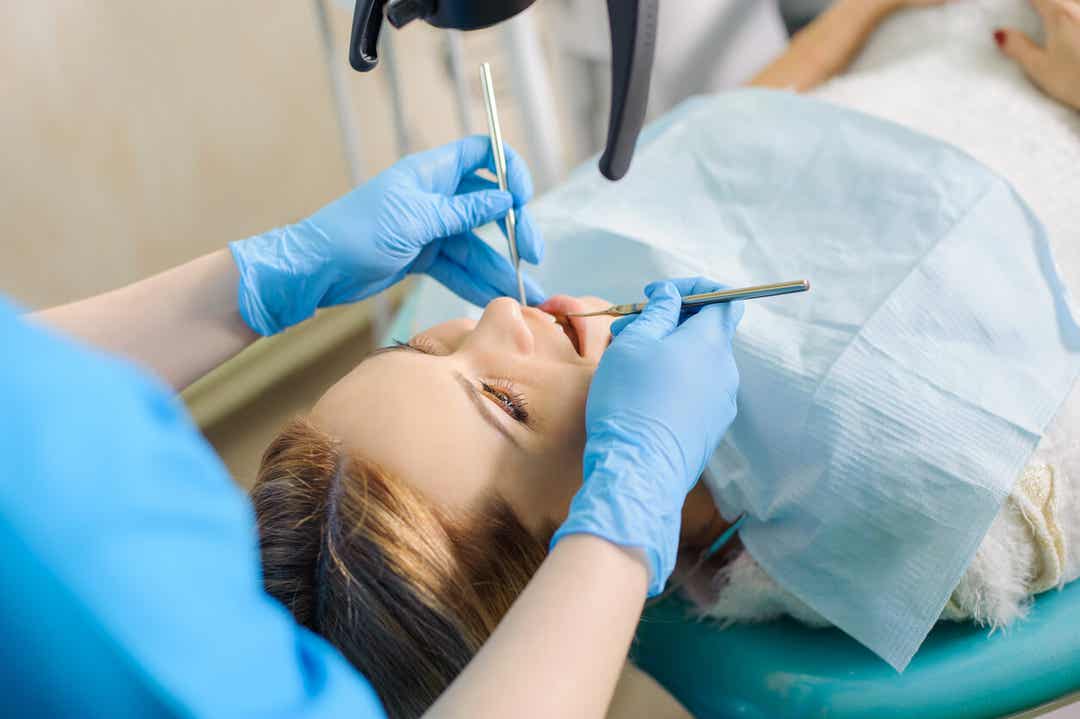 Een tandarts die aan de tanden van een vrouw werkt.