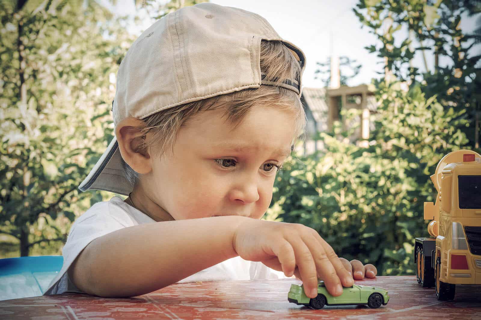 2-year-old boy playing with a toy car.