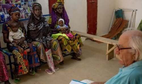 Een dokter in gesprek met een groep moeders in Afrika die het moederschap niet plannen.
