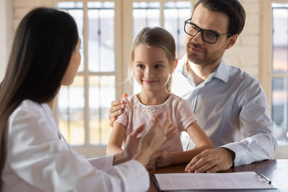 A father with his daughter in the pediatrician's office.