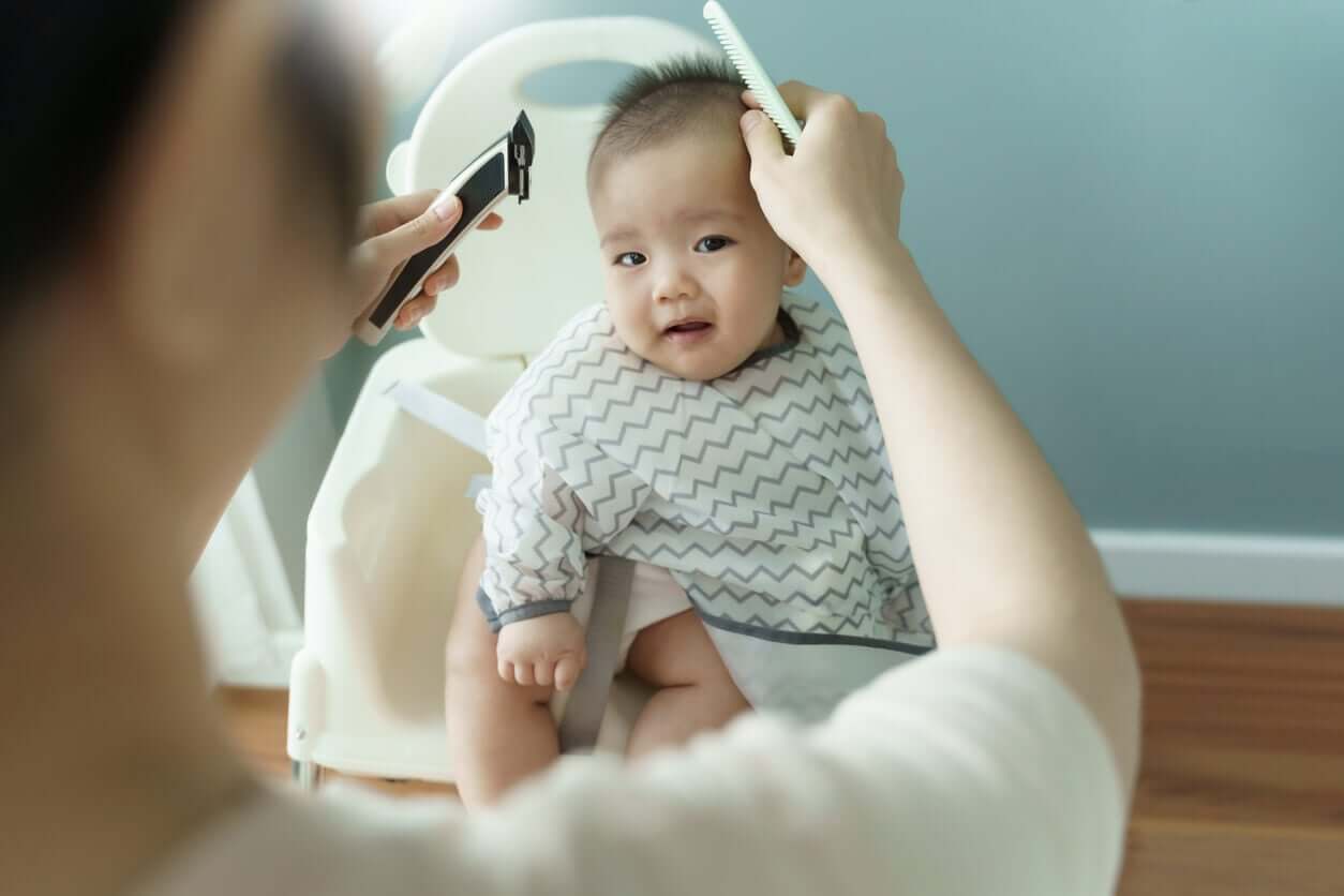 A mother preparing to cut her baby's hair.