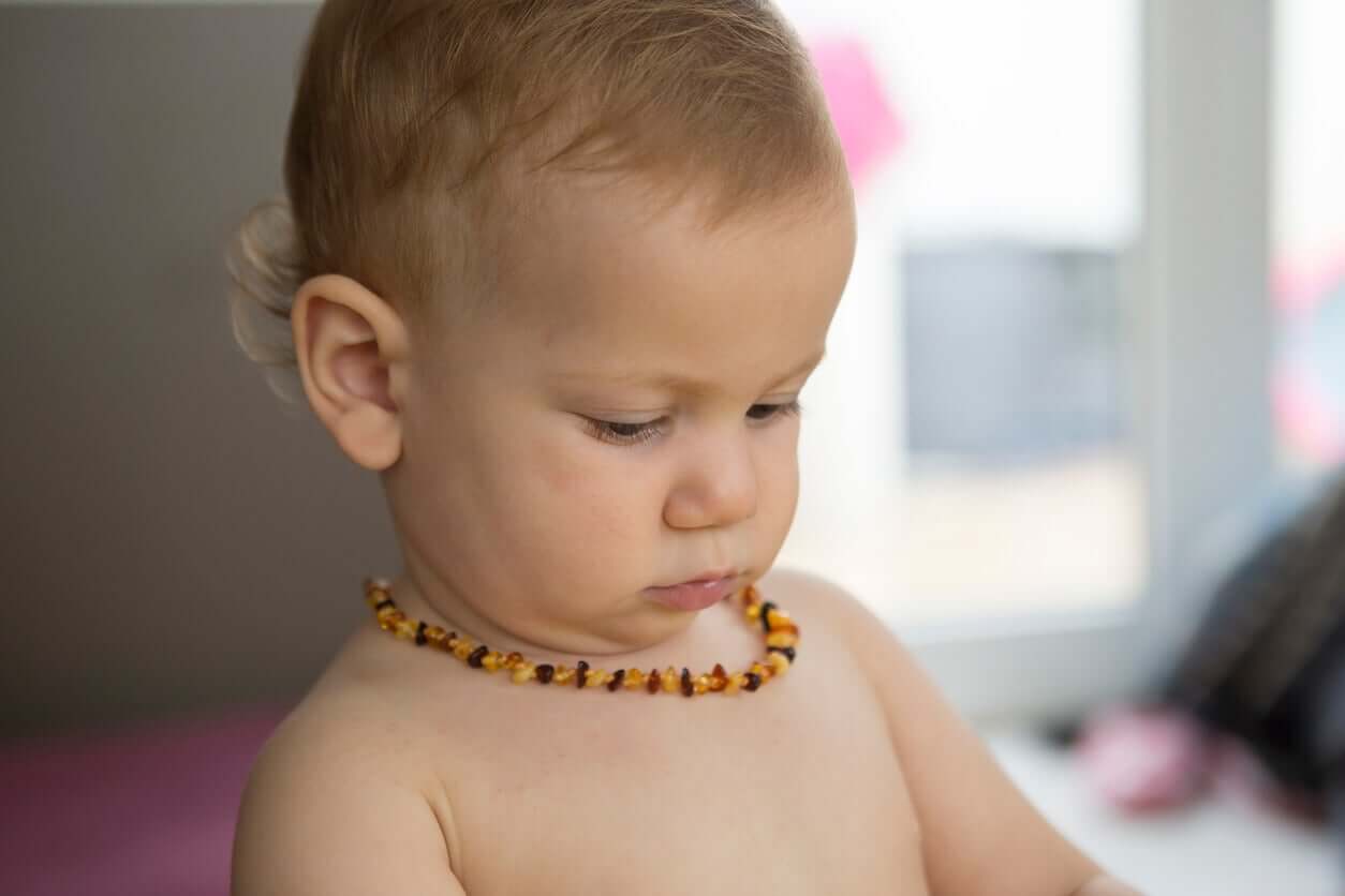 A baby wearing an amber necklace.