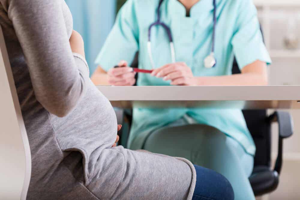En läkare som pratar med en gravid kvinna.