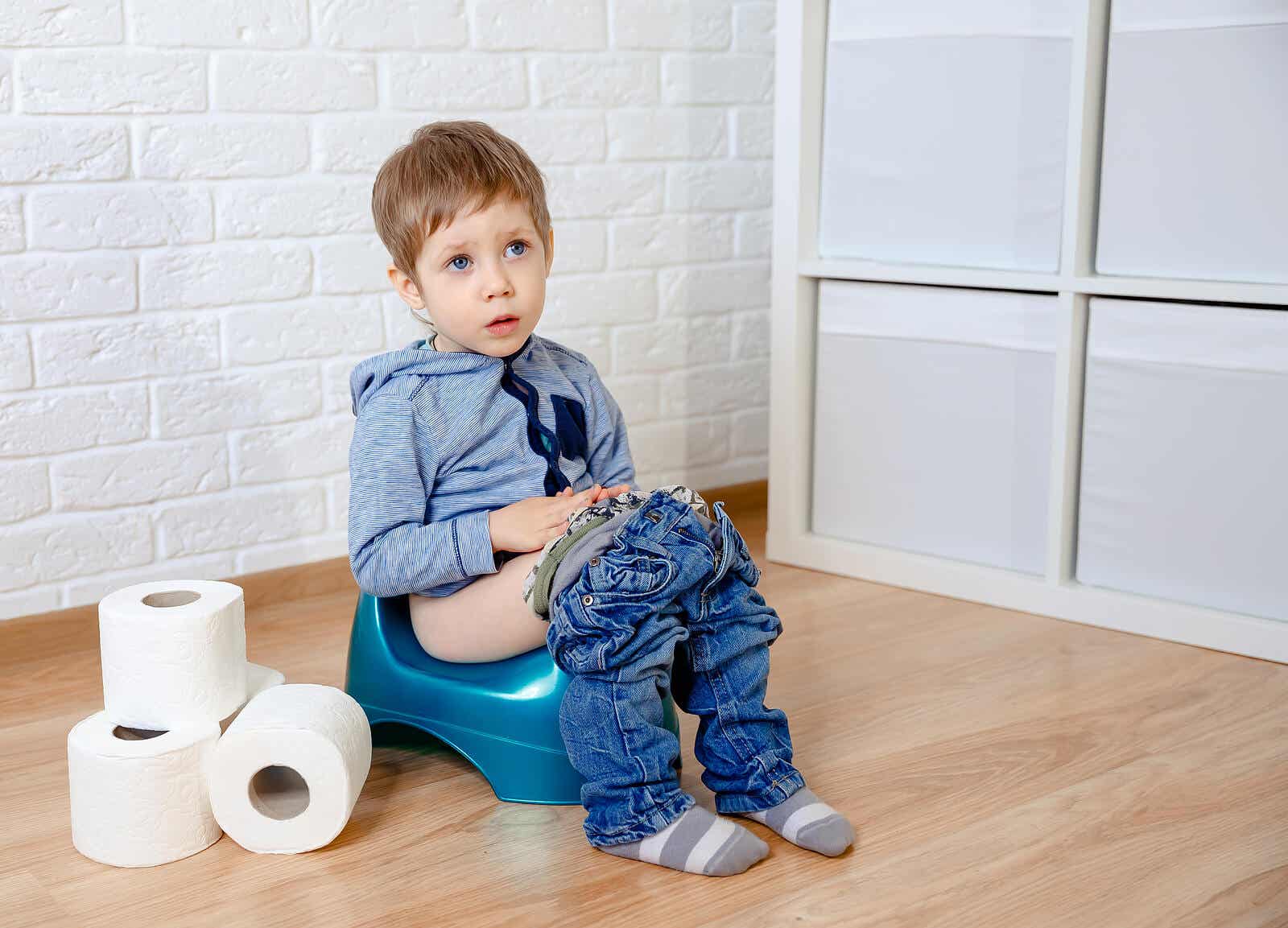 A toddler boy sitting on a potty.
