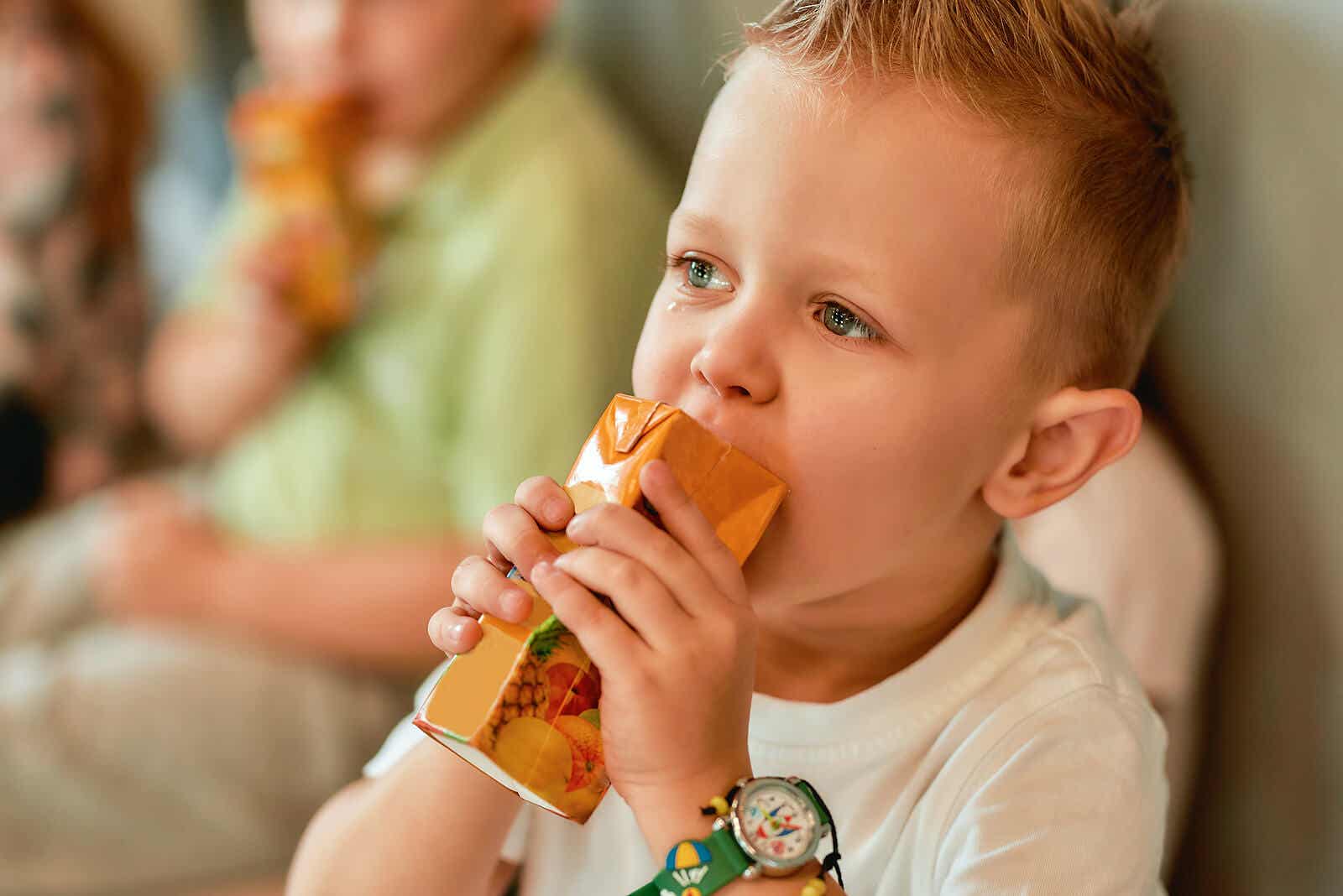 En gråtande pojke tröstar sig med juice.