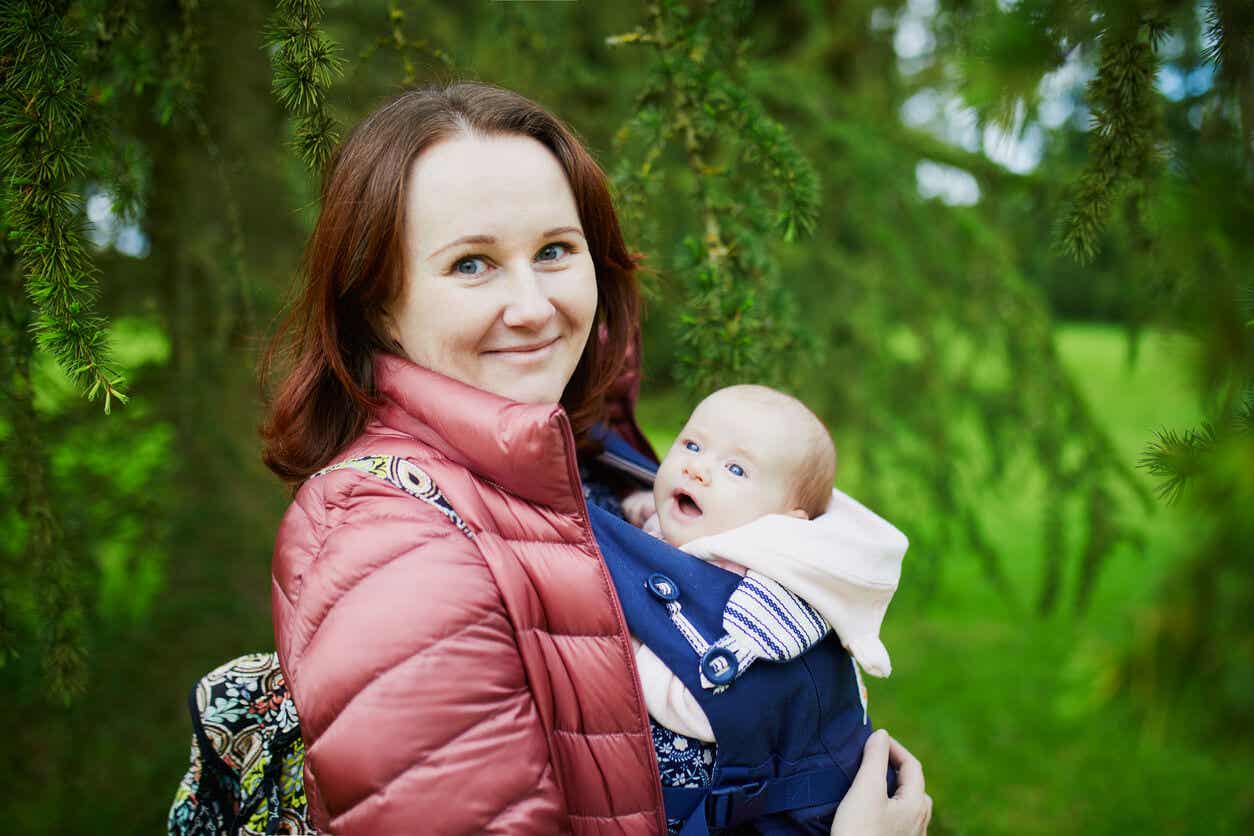 Een vrouw gaat wandelen met haar baby in een draagzak.