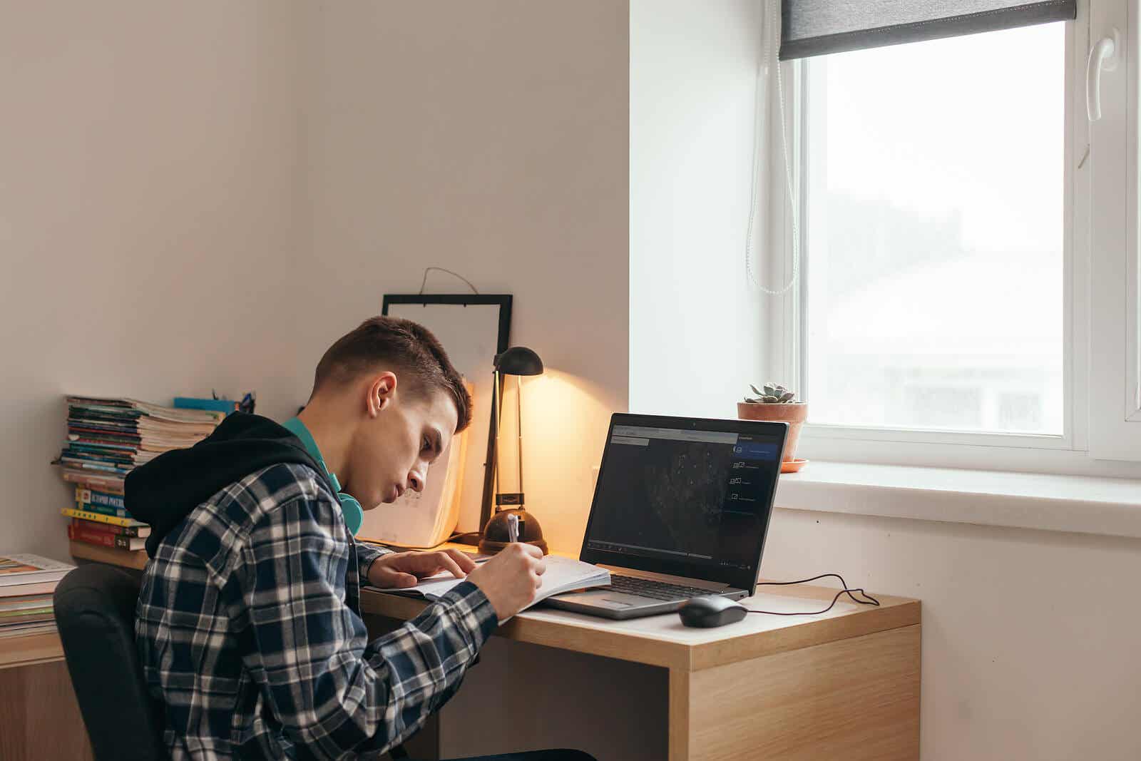 En tonåring som studerar vid sitt skrivbord.