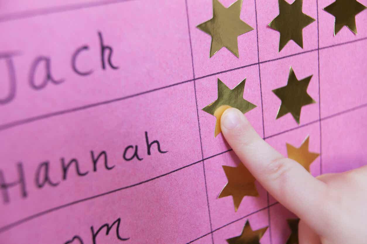 A child pointing to a start on a reward chart.