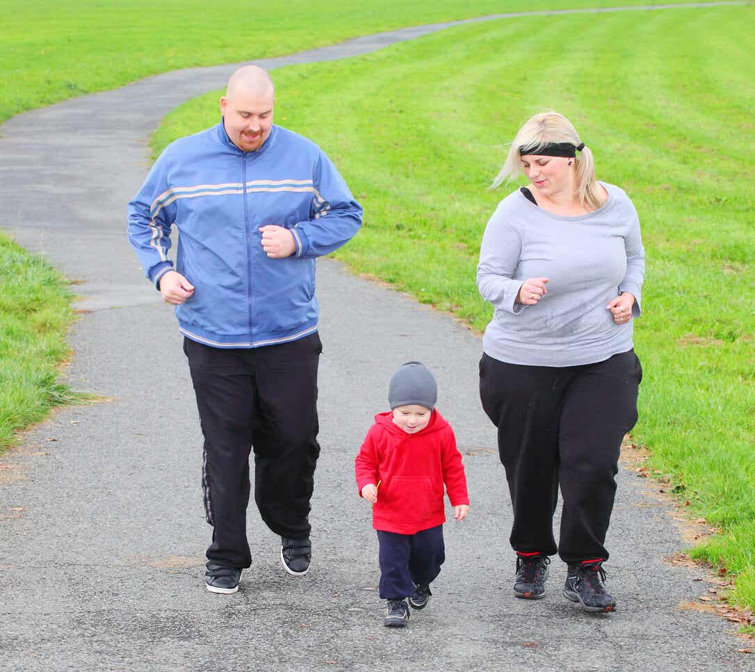 Rodzice z nadwagą biegają z maluchem.