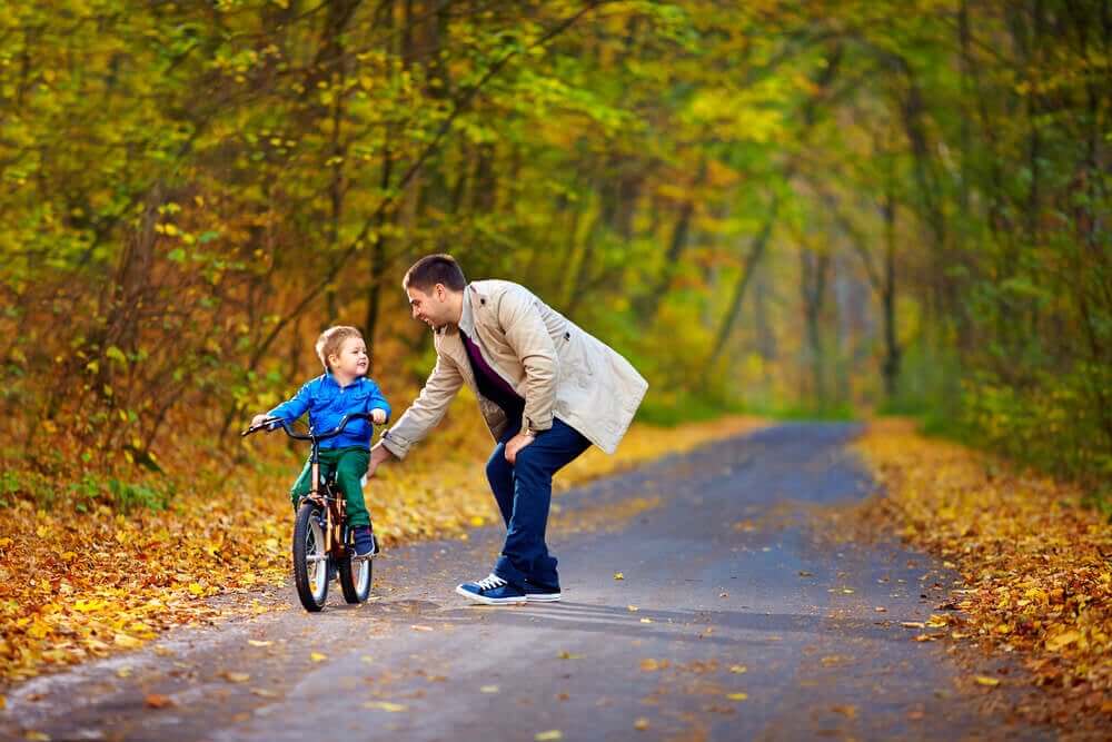 Een vader leert zijn zoontje fietsen