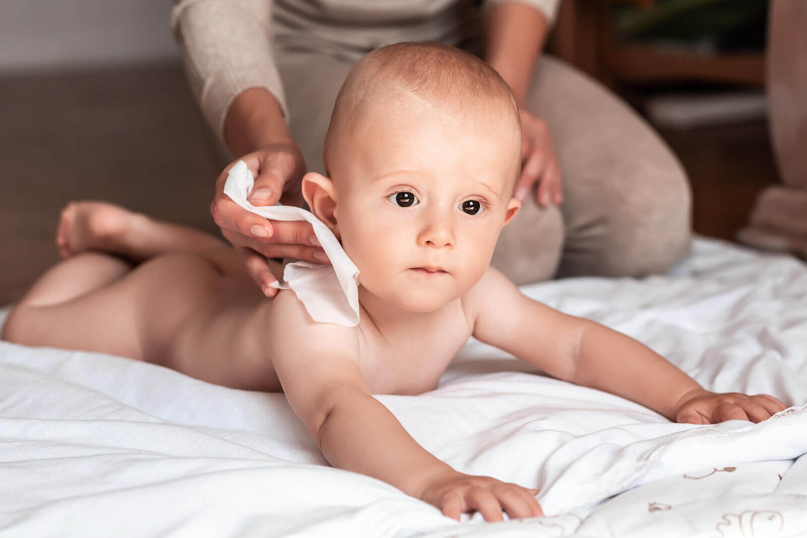 Een moeder maakt de huid van de baby schoon met een zacht doekje
