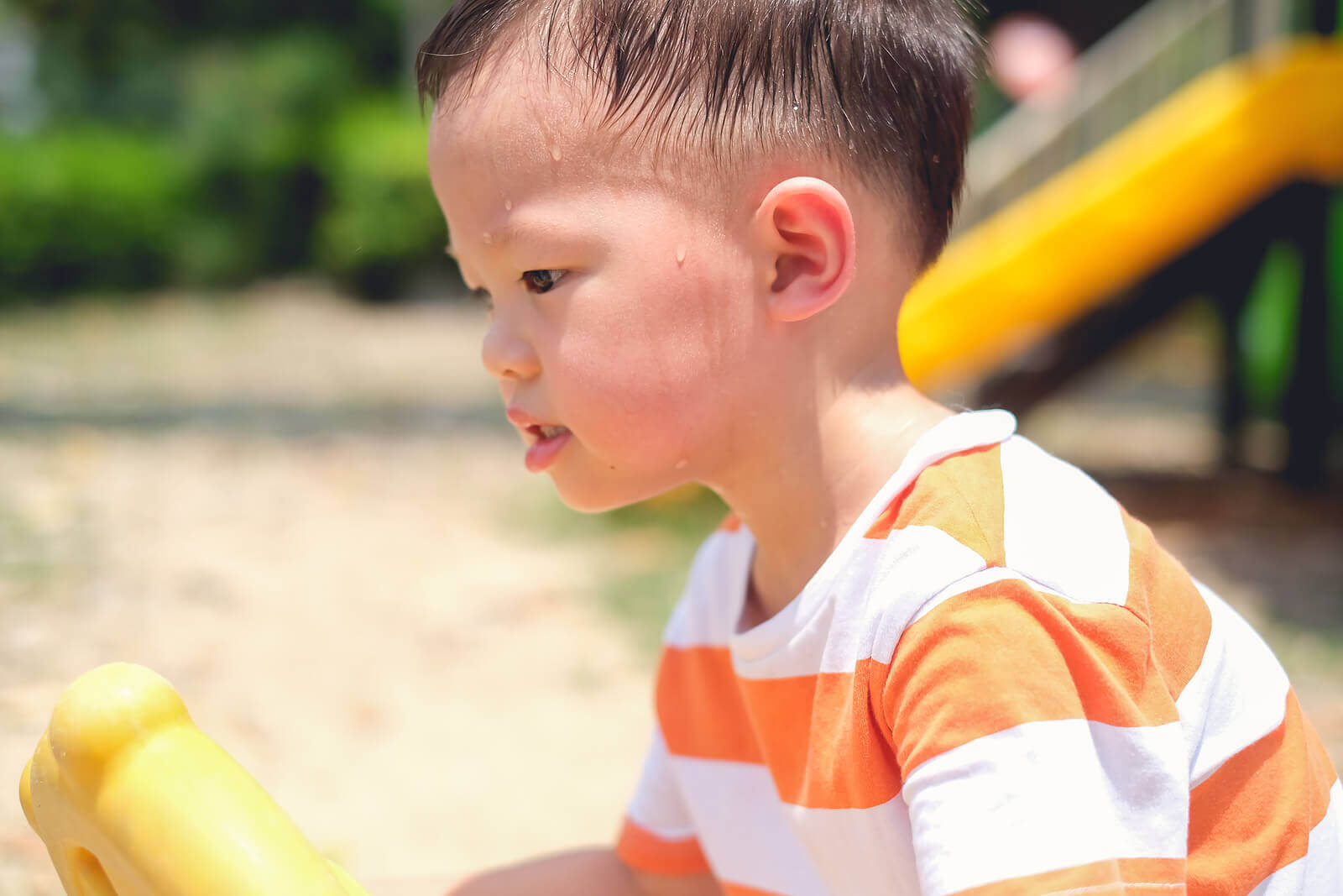 Boy sweating a lot because he is playing in the sun.