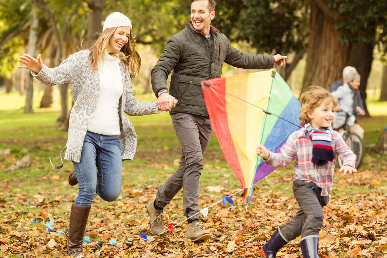 A family running outdoors with a kite.