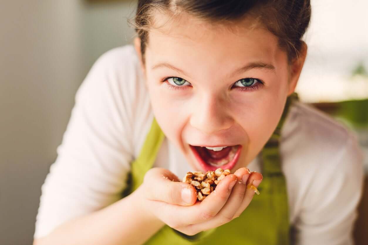 Et barn som putter granola i munnen hennes.