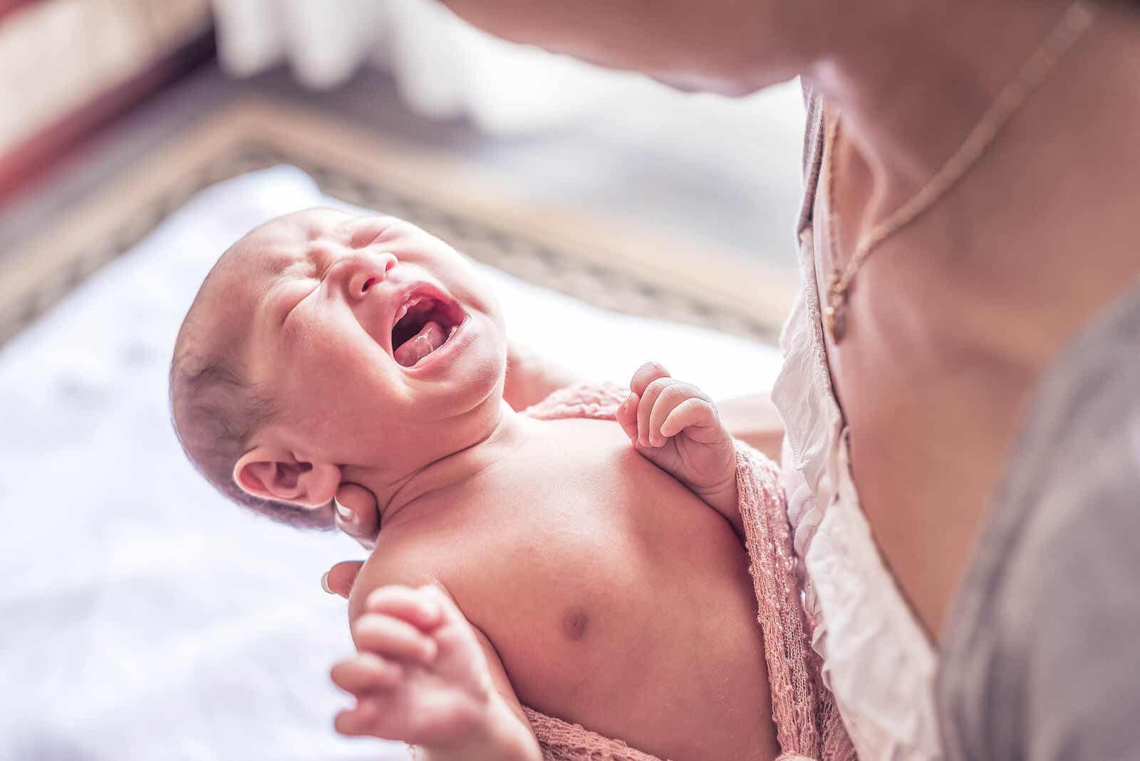 A mother holding her crying newborn.