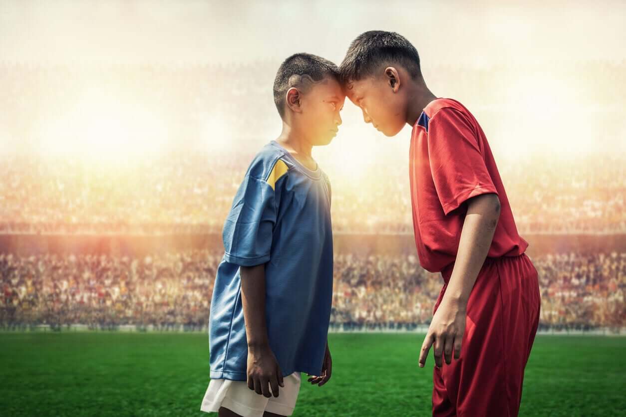 Two child soccer players from opposing teams glaring at one another.