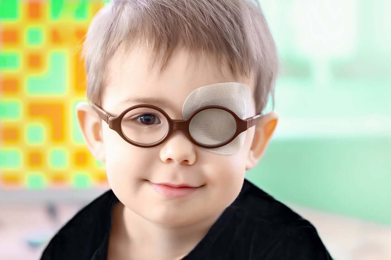 A toddler wearing a patch over his eye and glasses.