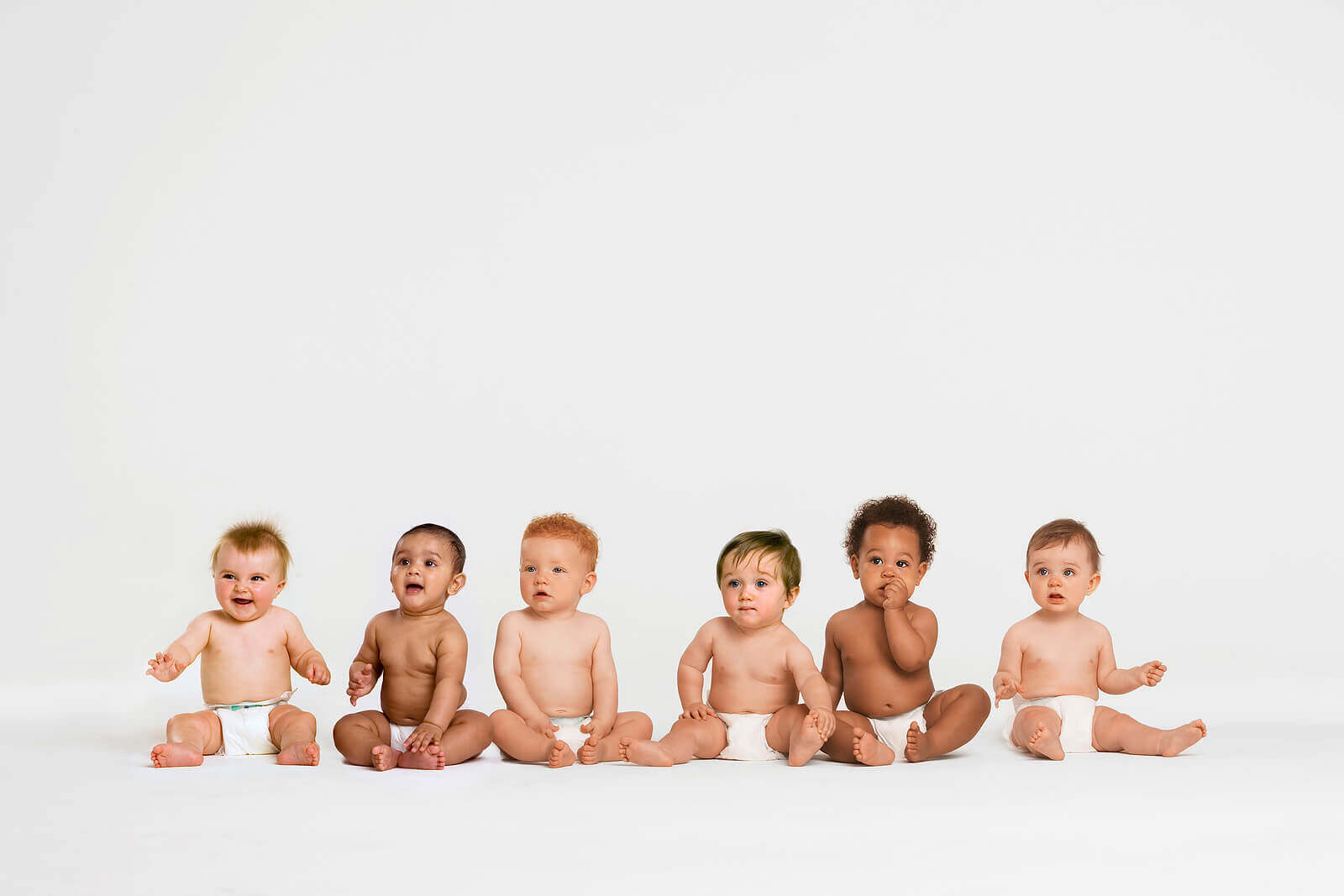 A row of babies in diapers sitting next to each other.