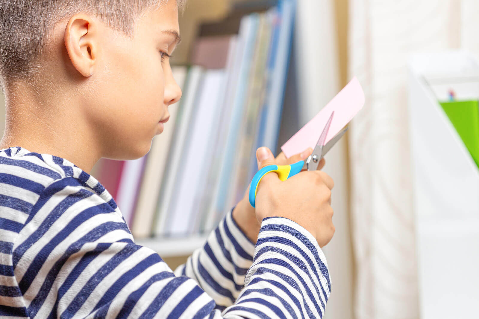 A boy cutting paper.