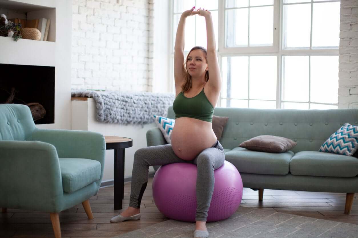 A pregnant woman sitting on an exercise ball.