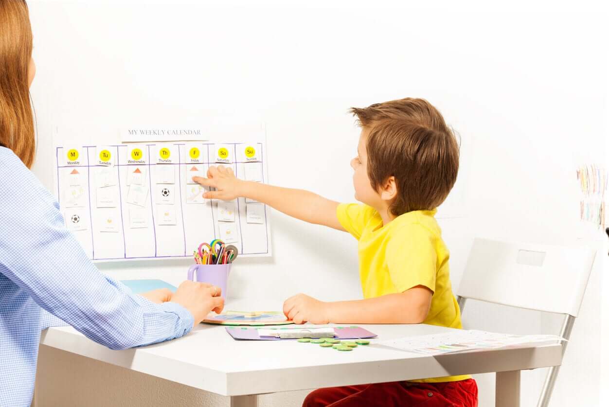 A mother and child working on a calendar.