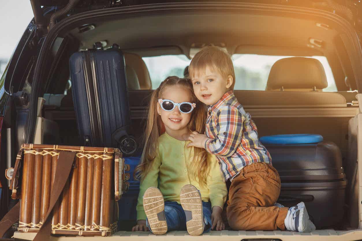 Two chidren sitting in the back of a SUV getting ready to go on a trip.